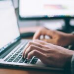 A hand typing on a computer. Image for Importance of Website for Business