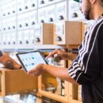 A warehouse worker checking his inventory on a pad